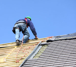 A man is laying roofing.