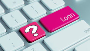 A laptop keyboard with a question mark and a loan button in bright pink.