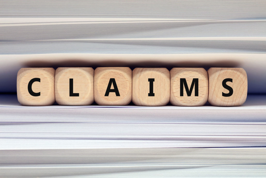 "CLAIMS" is spelled out in cubed, wood blocks.