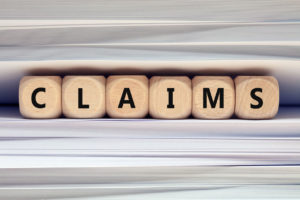 "CLAIMS" is spelled out in cubed, wood blocks.