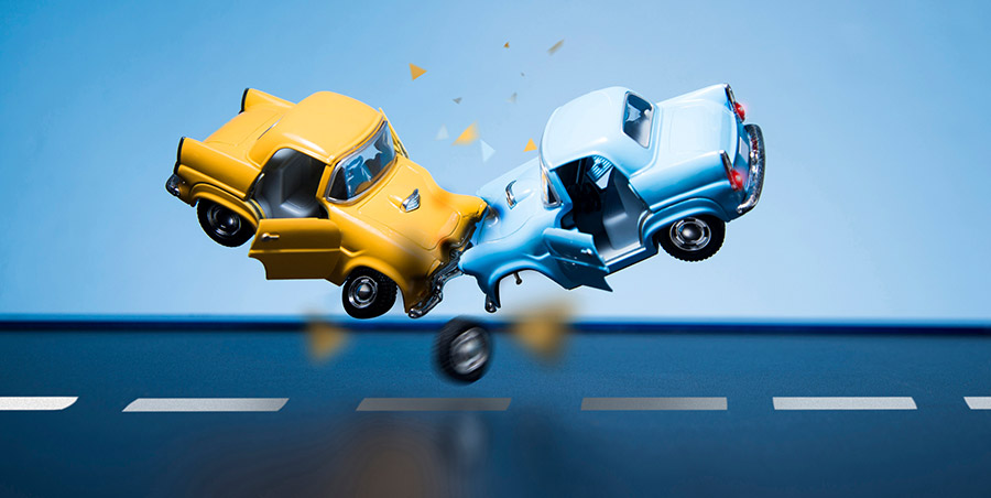 Two old fashioned toy cars are colliding in the air.