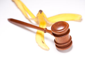A gavel laying over a banana peel.
